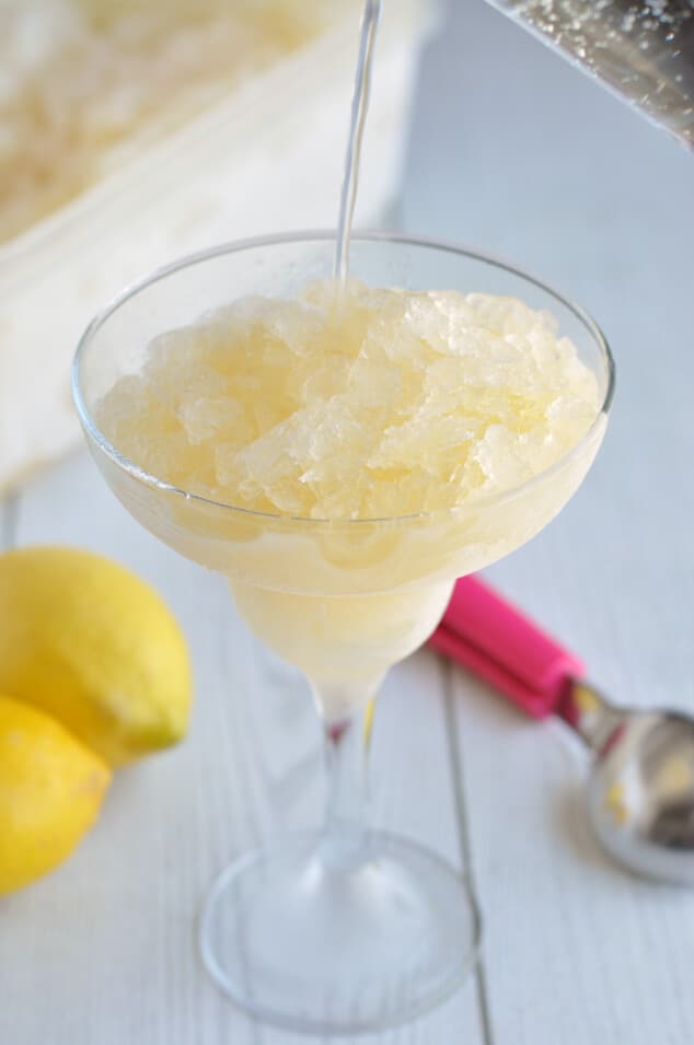 Lemon soda being poured into a glass of lemon vodka slush