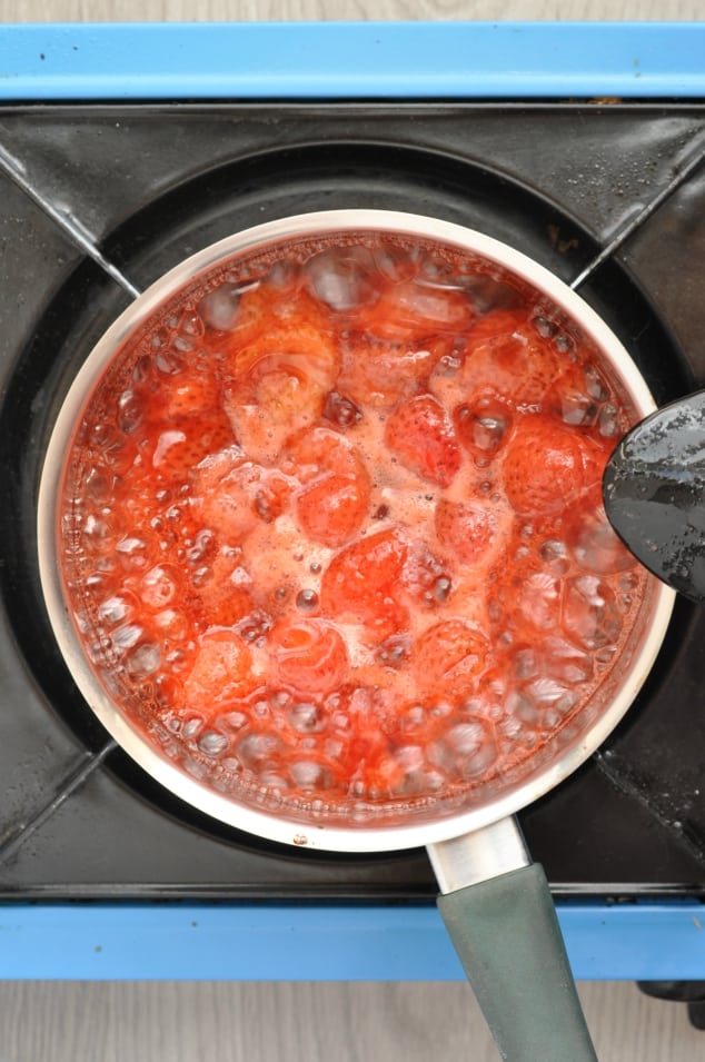 A saucepan filled with strawberries cooking
