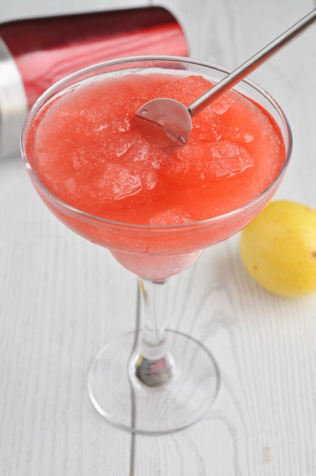 A metal spoon stirring Strawberry Vodka Slush Cocktail