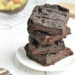 Four healthy vegan brownies stacked on a plate