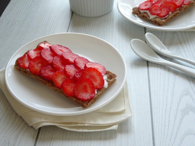 Healthy Strawberry Cheesecake Breakfast Toasts Recipe. Always wake up with a sweet tooth first thing in the morning? Then you NEED this quick, simple and healthy recipe! A whole wheat cracker slathered in a low calorie cheesecake-like spread, topped with fresh strawberries. I never knew I could eat cheesecake for breakfast and still be healthy!