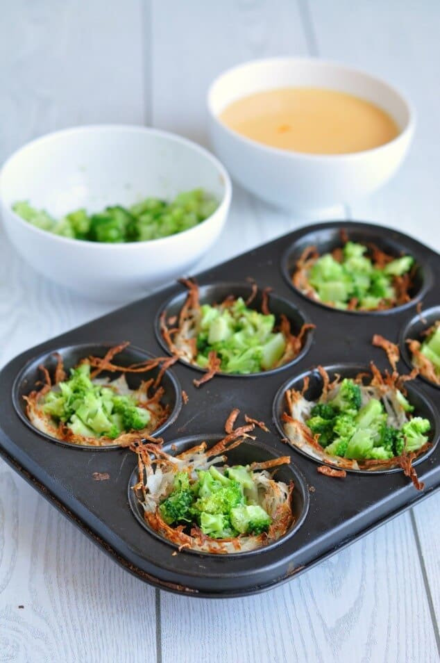 Partially made Healthy hash brown egg cups in a black muffin tin