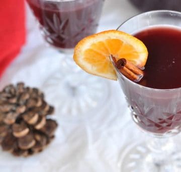 A glass of mulled wine with a cinnamon stick decoration