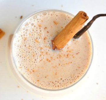 Overhead shot of healthy eggnog with cinnamon and vanilla stick decorations