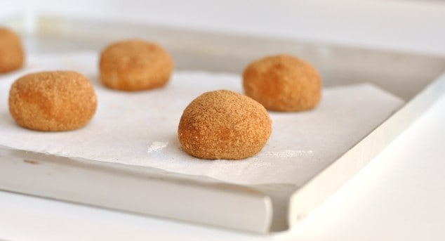 Balls of raw healthy snickerdoodle cookie dough on a baking tray